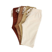 Corduroy Pants in Rust, Tan, Cream, and Beige with adjustable waistband and back pocket button detail, displayed in a folded stack.