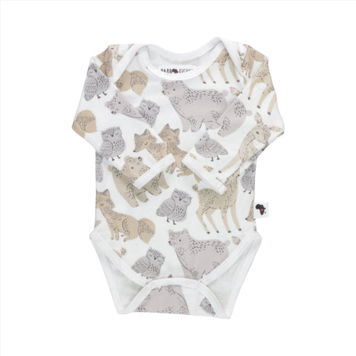A white long sleeved baby onesie with illustrations of owls, bears, foxes and deer in muted, neutral tones.