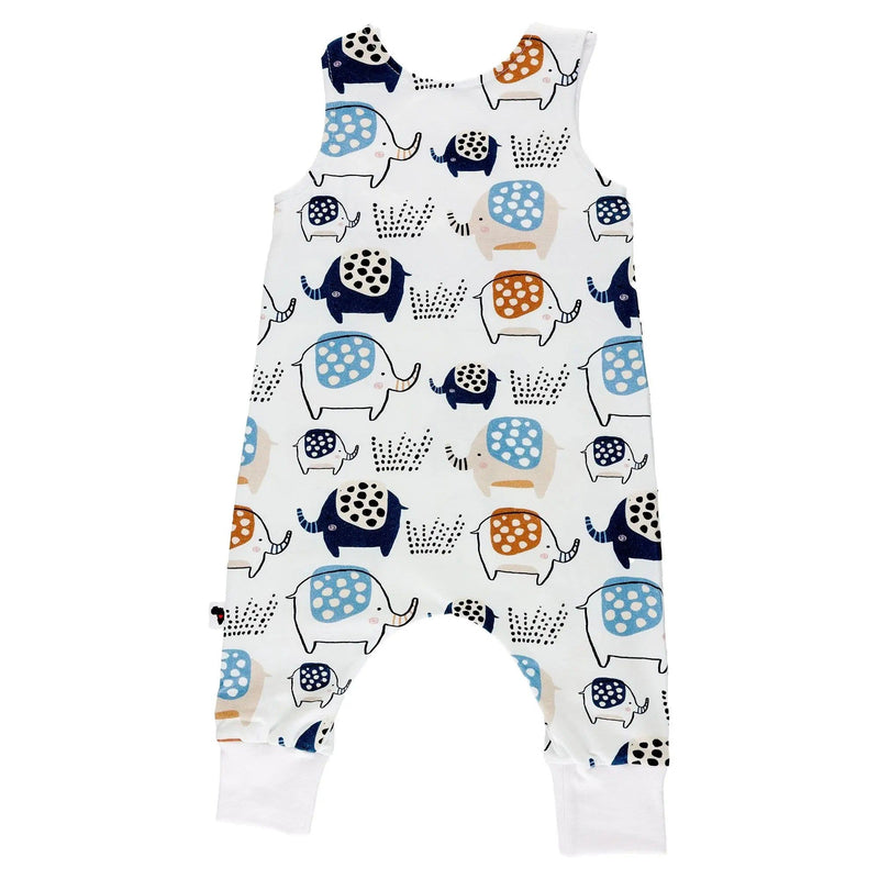 Back view of a sleeveless harem-style baby romper in white, featuring a playful elephant print in rust, navy, and soft blue, with shoulder press studs and fold-over ankle cuffs.