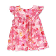 Back view of a Mocca dress with a soft pink watercolour floral print and ruffled sleeves from BabaFishees