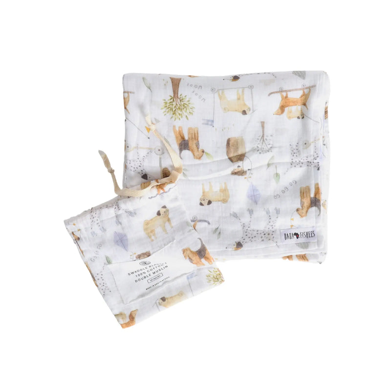 White cotton muslin swaddle blanket with playful dog print and matching pouch from Baba Fishees.
