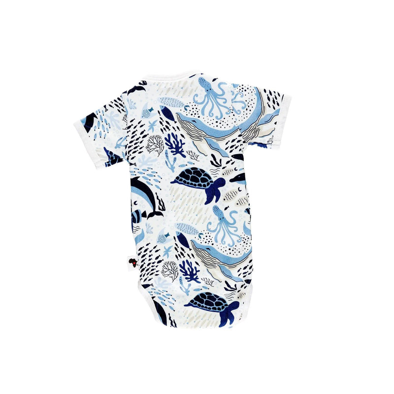Back view of a white short-sleeve wrap onesie featuring an African sea life print with dolphins, turtles, fish, and coral in shades of blue from BabaFishees.