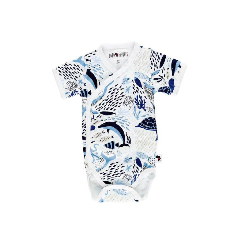 Front view of a white short-sleeve wrap onesie featuring an African sea life print with dolphins, turtles, fish, and coral in shades of blue from BabaFishees.