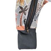 Close-up of a zippered foot with an airforce blue cuff and a printed fabric body featuring safari-style animal and palm tree motifs in beige, gray, orange, and brown.