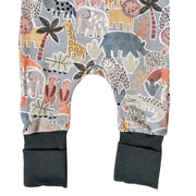 A closeup of the legs of the adapt romper - meerkat manor pair with an all-over safari animal print on a light gray background, featuring airforce blue ribbed cuffs at the bottom.