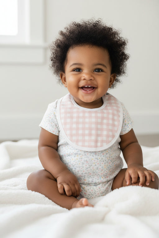 Baby bib with pink and white checkered pattern on a white background
