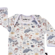Top close-up of long-sleeve Classic Onesie - Fin and Friends showing the white-bound envelope neckline, long sleeves and Baba Fishees neck label