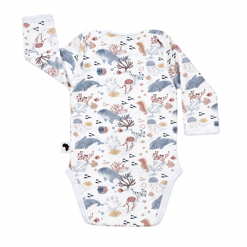 Back view of a white Classic Onesie - Finn and Friends with long sleeves, an envelope neckline and an all-over dolphin, whale, jellyfish, seahorse, fish and coral print