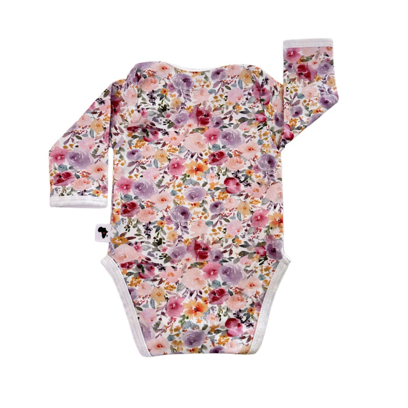 Floral Fantasy long-sleeve baby onesie shown from the back, with an all-over floral print, white neck binding and long sleeves