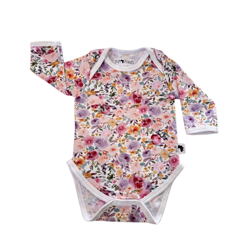 Floral Fantasy long-sleeve baby onesie shown from the front, featuring an envelope neckline, all-over floral print and white binding