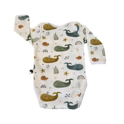 A long-sleeve baby bodysuit with an all-over whimsical ocean-themed print featuring whales, starfish, seashells, rainbows, and seaweed.