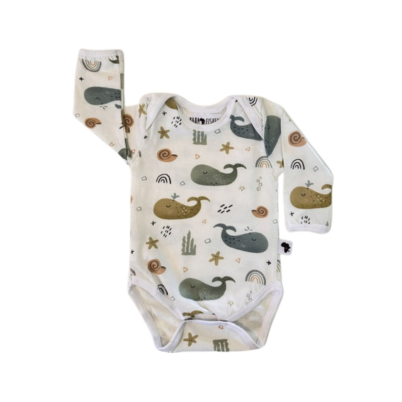 A long-sleeve baby bodysuit with an all-over whimsical print of whales, starfish, seashells, and rainbows on a white-colored fabric.
