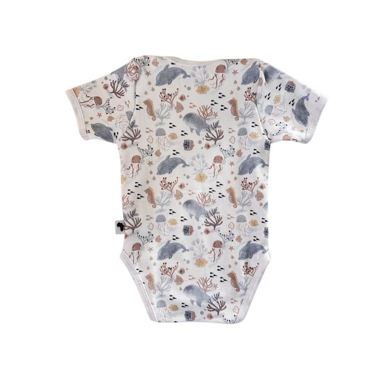 Front view of a white Classic Onesie - Fin and Friends with short sleeves, an envelope neckline and a muted dolphin, whale, jellyfish, seahorse, fish and coral print