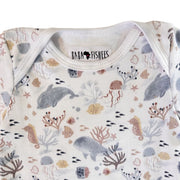 Neckline close-up of short-sleeve Classic Onesie - Fin and Friends showing the white-bound envelope neck, Baba Fishees label and detailed marine print