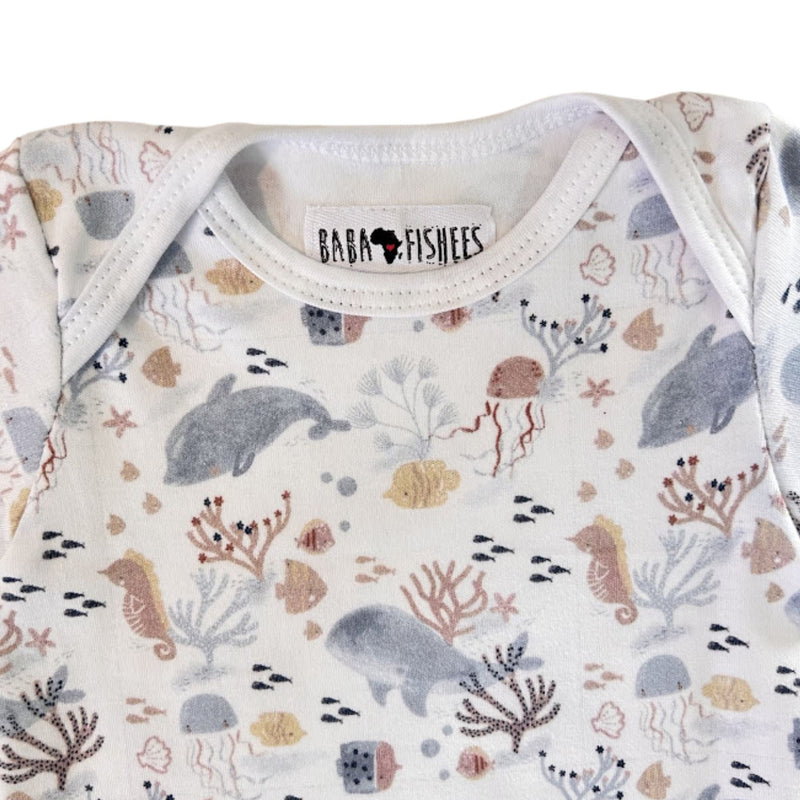 Neckline close-up of short-sleeve Classic Onesie - Fin and Friends showing the white-bound envelope neck, Baba Fishees label and detailed marine print