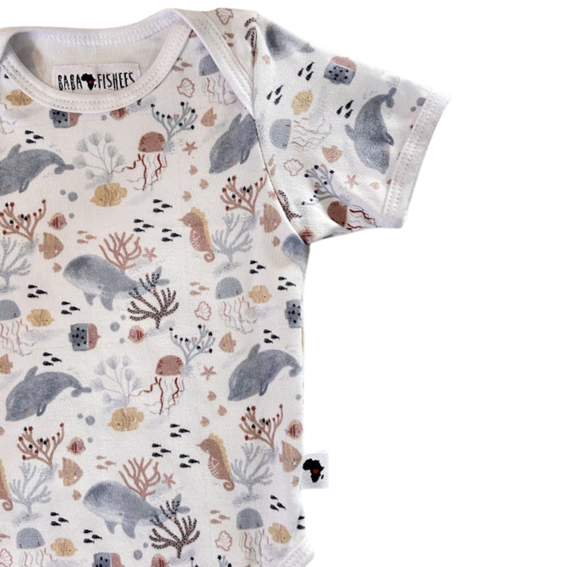 Side close-up of short-sleeve Classic Onesie - Fin and Friends showing the sleeve finish, curved leg opening, Baba Fishees Africa label and underwater illustrations