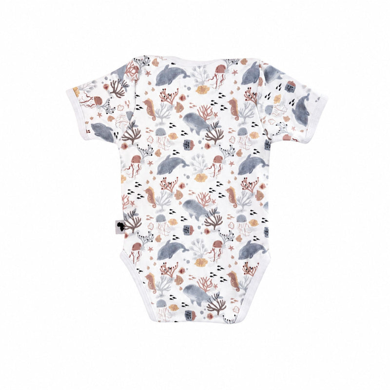 Back view of a white Classic Onesie - Finn and Friends with short sleeves, an envelope neckline and a muted dolphin, whale, jellyfish, seahorse, fish and coral print