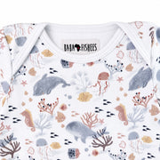 Neckline close-up of short-sleeve Classic Onesie - Finn and Friends showing the white-bound envelope neck, Baba Fishees label and detailed marine print