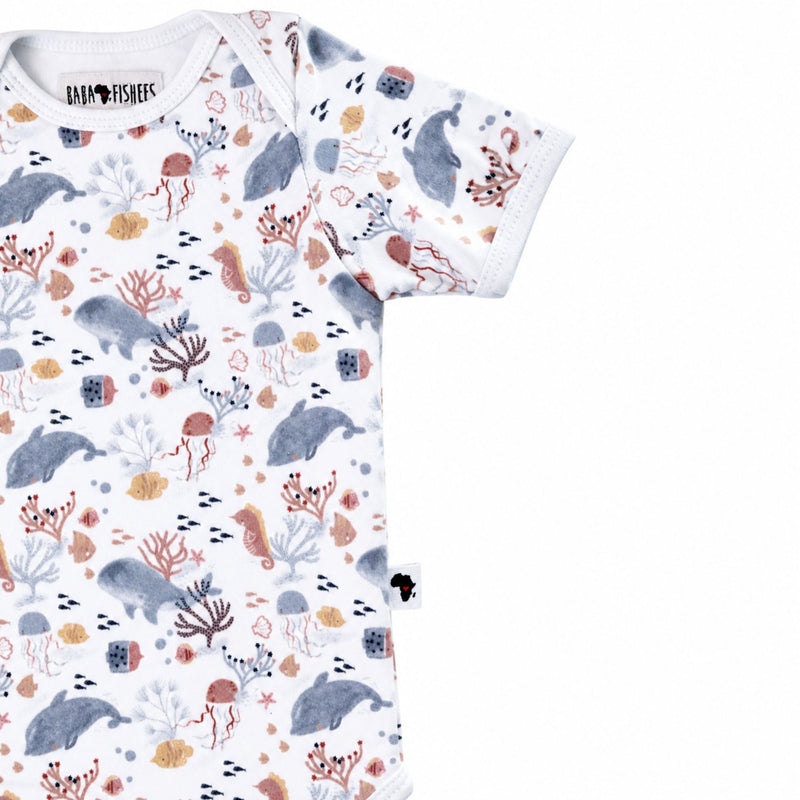 Side close-up of short-sleeve Classic Onesie - Finn and Friends showing the sleeve finish, curved leg opening, Baba Fishees Africa label and underwater illustrations