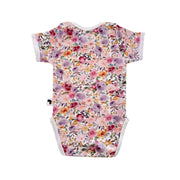 Floral Fantasy short-sleeve baby onesie shown from the back, with an all-over floral print and white-trimmed leg openings