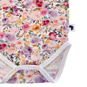 Close-up of the Floral Fantasy short-sleeve onesie’s crotch area, showing the white press-stud fastening and floral print