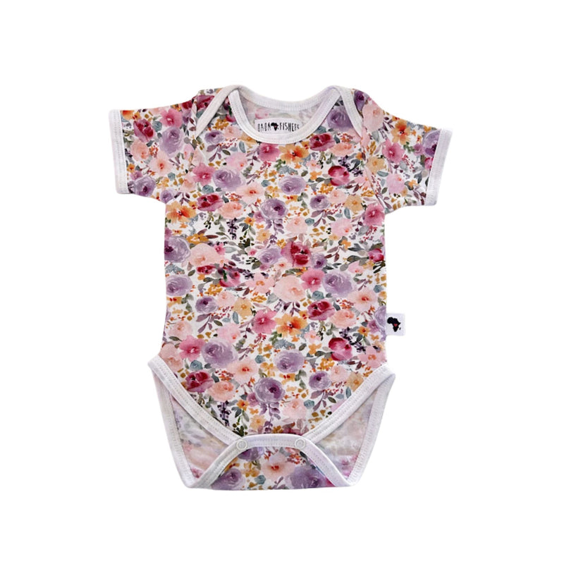 Floral Fantasy short-sleeve baby onesie shown from the front, featuring an envelope neckline, short sleeves and all-over floral print
