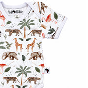 A short-sleeve baby bodysuit by Baba Fishees, featuring a safari-themed print with giraffes, elephants, flamingos, palm trees, and cheetahs on a white background.