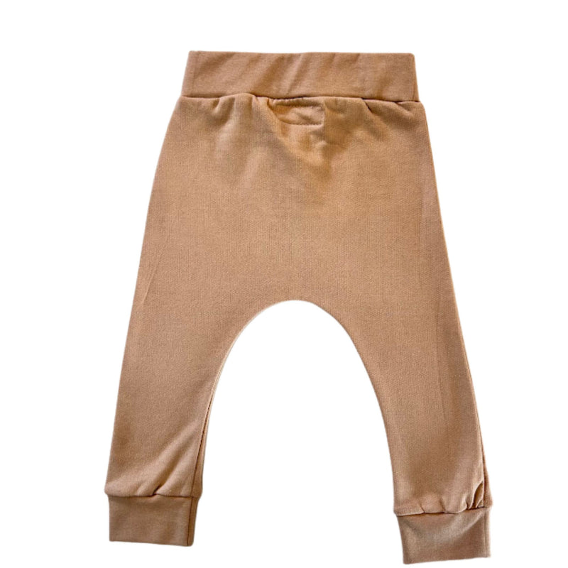 Back view of a pair of toddler's cuff pants in a caramel colour, featuring an elastic waistband and ribbed ankle cuffs.