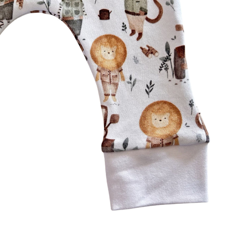 Close-up of Jeep Safari cuff pants fabric showing lion print and soft white ankle cuff