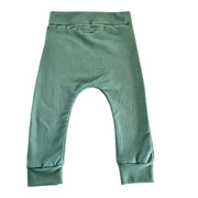 Back view of a pair of sage green cuff pants with a wide elastic waistband and cuffed ankles.