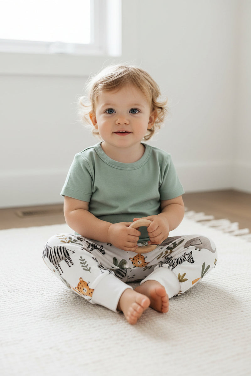 Baby cuff pants in white Zebra Party safari animal print with zebras, elephants, palms and cuffed ankles on a child