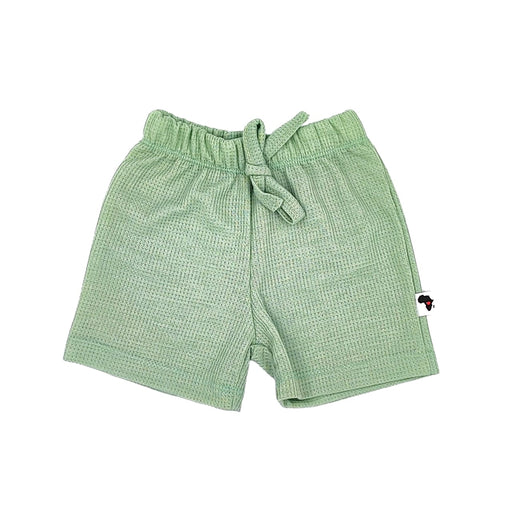A pair of sage green shorts made from waffle fabric, featuring a textured pattern. The shorts have an elastic waistband and a simple, comfortable design.