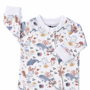 Finn and Friends footy romper neckline with white neckband, protective zip cover and white sleeve cuffs beside a pastel dolphin, fish and coral print.