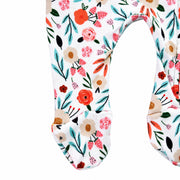 Close-up of the built-in footies on the Oh So Pretty Footy Romper, featuring colourful flowers, leaves and botanical details on white cotton fabric.