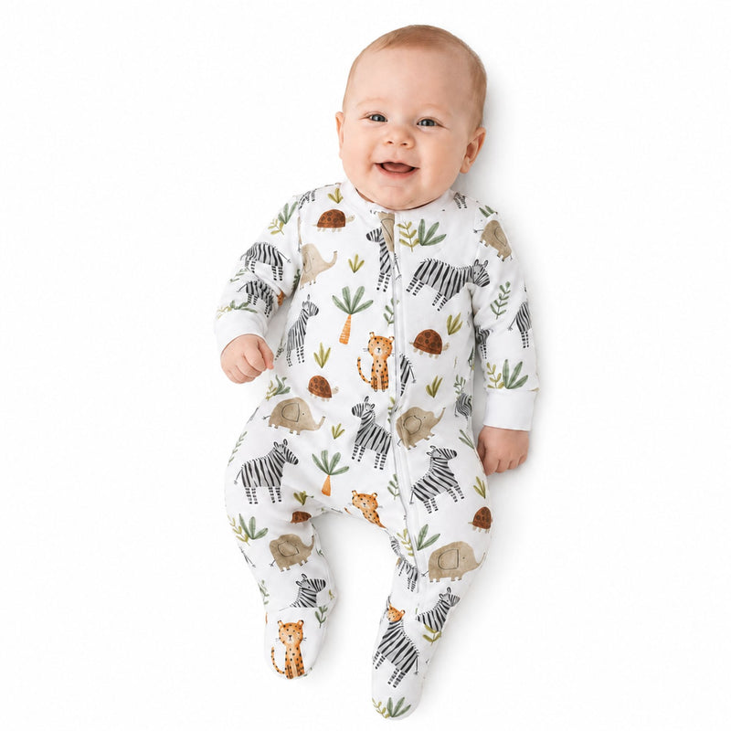 Baby wearing a White footy romper featuring a playful Zebra Party print with zebras, elephants, cheetahs, and tortoises from Baba Fishees