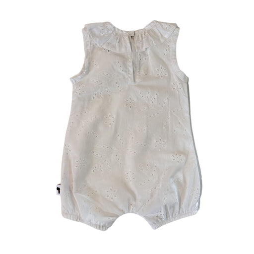 Back view of the white broderie anglaise baby romper, showing the sleeveless shape, keyhole opening and single press-stud fastening at the neckline.