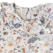 Front neckline close-up of the Two By Two Frilly Neck Romper showing the gathered frill collar and detailed dolphins and sea-life print