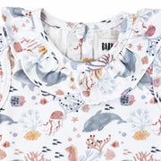 Front neckline close-up of the Two By Two Frilly Neck Romper showing the gathered frill collar and detailed dolphins and sea-life print