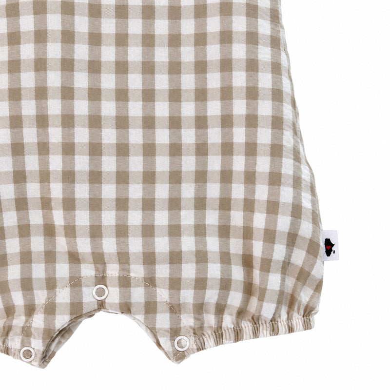 Frilly Neck Romper Gingham - Stone lower detail, showing three white crotch press studs, elasticated leg hems, curved seam stitching and side brand label.