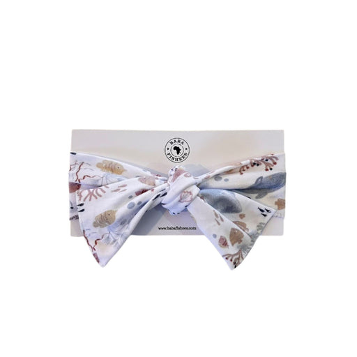 Babies headband in a Baba Fishees Finn and Friends print on a white cardboard with Baba Fishees logo