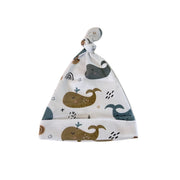 Front view of knot beanie in Whales on White print with blue, grey and mustard whales.