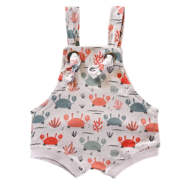 Knot Dungaree - Crab Gang in white background with pink and pale blue crabs print, sea-inspired details and knot shoulder straps