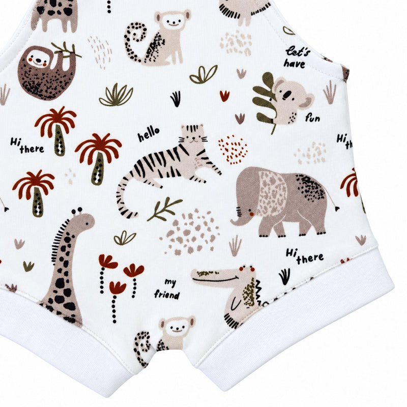 Knot Dungaree - Hi There White, lower-front detail showing white leg cuffs and stitching beneath a beige tiger, taupe elephant and giraffe, with rust palm trees.