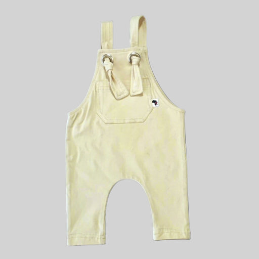 Long knot dungarees in cream color for babies and toddlers, featuring adjustable shoulder ties and a soft, comfortable fabric
