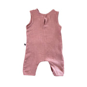 A sleeveless baby romper in orchid pink textured muslin fabric, featuring a small keyhole cutout at the back neckline and short leg openings, shown flat on a white background.