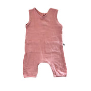 A sleeveless baby romper in orchid pink textured muslin fabric, featuring a split neckline and two front patch pockets, shown flat on a white background.