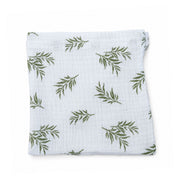 Swaddle Blanket - Wild Olive folded on a white background, showing the soft white double muslin and repeating olive-green leafy branch print