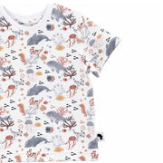 A short-sleeve child's t-shirt with an all-over underwater-themed print featuring whales, dolphins, jellyfish, seahorses, and coral in muted gray, terracotta, and beige tones.