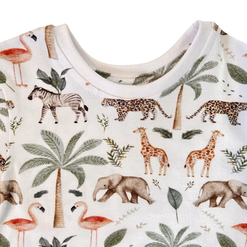 Neckline close-up of Tee Shirt – Two By Two showing the white ribbed round neck, neat topstitching and detailed zebra, leopard, giraffe and elephant illustrations