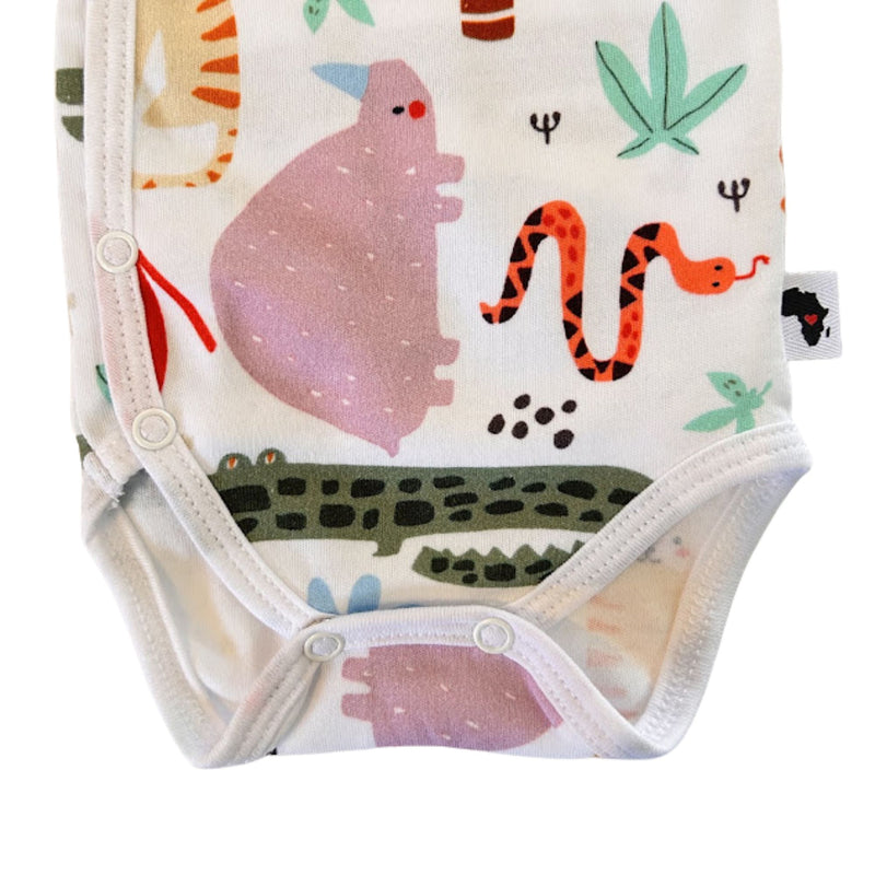 A close-up of a baby wrap onesie bodysuit featuring a colorful safari animal print on a white background. The print includes a pink hippopotamus, an orange and black snake, a green crocodile, and green leaves.